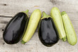Eggplants and zucchini on weathered wooden board background