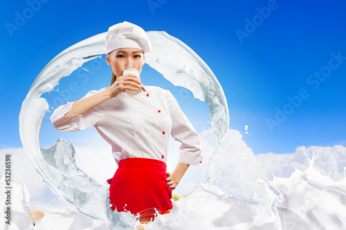 Photo: Asian female cook against milk splashes Asian female cook against milk splashes