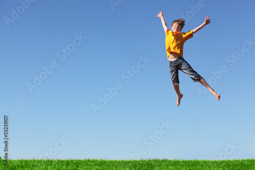 Photo: Fr√∂hlicher Junge springt hoch Fr√∂hlicher Junge springt hoch