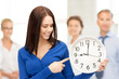 Photo: woman holding big clock woman holding big clock