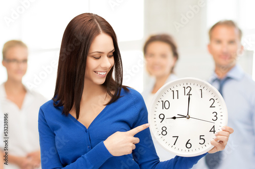 Photo: woman holding big clock woman holding big clock