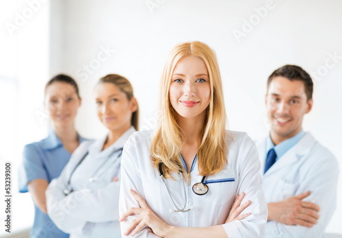 Photo: female doctor in front of medical group female doctor in front of medical group