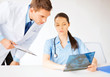 two medical workers looking at x-ray