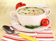 Photo: Nourishing soup in pink pan on wooden table close-up Nourishing soup in pink pan on wooden table close-up