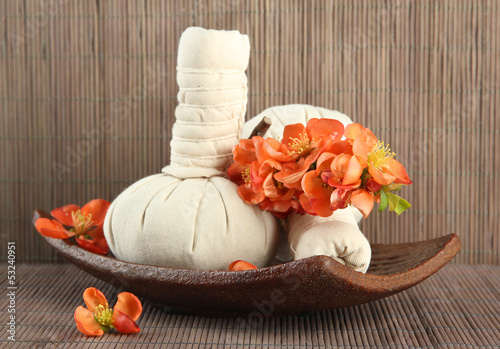 Photo: Herbal compress balls for spa treatment on bamboo background Herbal compress balls for spa treatment on bamboo background