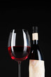 Glass of wine with bottle on bright background