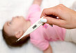 Sick baby being checked for fever.