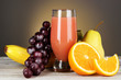 Glass of fresh juice on table on gray background