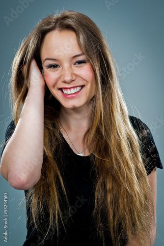Photo: Young Happy Woman Smiling and Touching Her Hair Young Happy Woman Smiling and Touching Her Hair