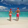 Photo: Couple in santa's hat on a beach at Maldives Couple in santa's hat on a beach at Maldives
