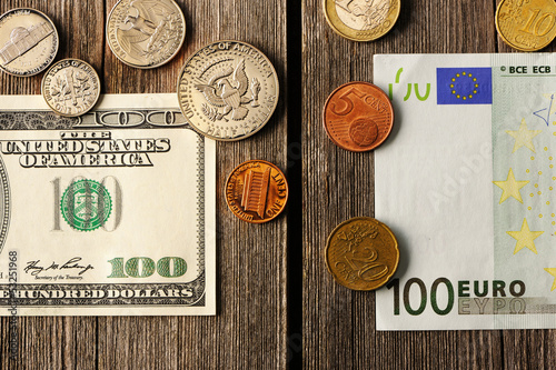 Photo: US and euro money over wooden background US and euro money over wooden background