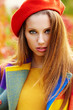 Beautiful elegant woman standing in a park in autumn