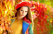 Beautiful elegant woman standing in a park in autumn