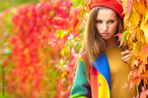 Photo: Beautiful elegant woman standing in a park in autumn Beautiful elegant woman standing in a park in autumn