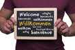 Photo: mann hält willkommenstafel mann hält willkommenstafel