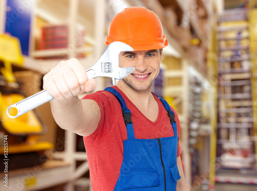 Photo: smiling worker with big spanner smiling worker with big spanner