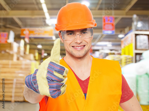 Photo: professional young worker with thumbs up at shop professional young worker with thumbs up at shop