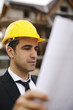 Photo: Architect in construction site looking at building plans Architect in construction site looking at building plans
