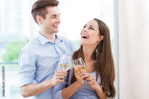 Photo: Couple drinking wine in modern apartment Couple drinking wine in modern apartment