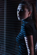 Foto: Sexy woman looking through window with jalousie Sexy woman looking through window with jalousie