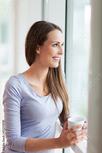Photo: Woman looking through window Woman looking through window