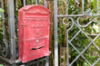 Traditional old English red postbox hang on gate