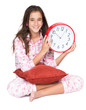 Photo: Girl wearing pajamas and holding a clock isolated on white Girl wearing pajamas and holding a clock isolated on white