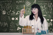 Beautiful doctor looking at liquid flasks at laboratory