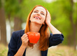 Redhead girl with orange cup at outdoor