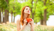Redhead girl with orange cup at outdoor