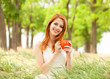 Redhead girl with orange cup at outdoor