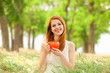 Redhead girl with orange cup at outdoor