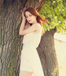 Redhead girl near tree at countryside