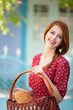 Redhead girl in red dress at outdoor near old house