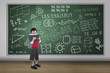 Boy reading book with written chalkboard