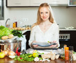 Foto: Positive housewife cooking full fish with lemon Positive housewife cooking full fish with lemon