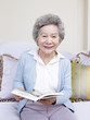 senior woman holding a book and smiling