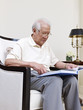 senior asian man reading a book at home