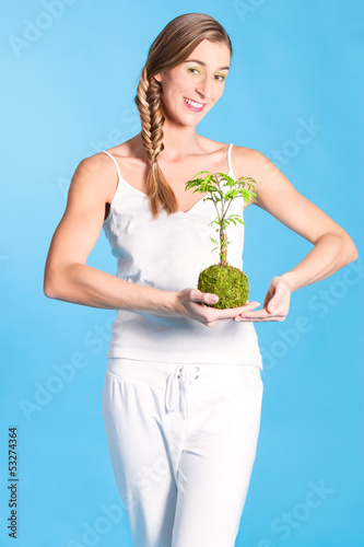 Photo: Young Woman holding a small tree Young Woman holding a small tree
