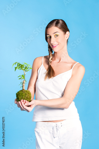 Photo: Young Woman holding a small tree Young Woman holding a small tree