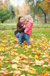 Mother and daughter gathering autumn leaves