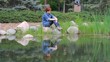 Red-haired girl sitting on the pond