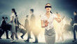 Businesswoman in blindfold among group of people