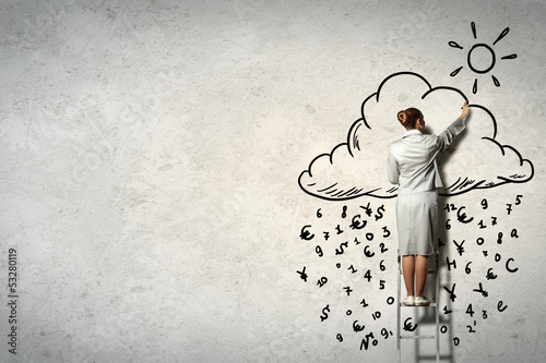 Photo: Woman standing on ladder drawing on wall Woman standing on ladder drawing on wall