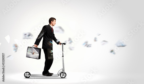 Photo: Businessman riding scooter Businessman riding scooter