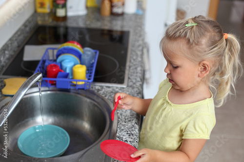 Photo: Little girl playing in the kitchen Little girl playing in the kitchen