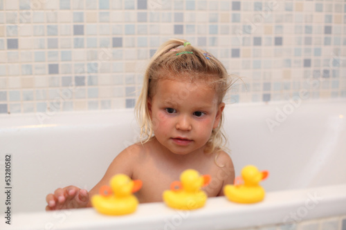 Photo: Little girl playing with rubber ducks in the bathtub Little girl playing with rubber ducks in the bathtub