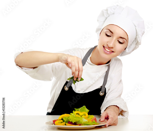 Photo: Portrait of a young cook in uniform preparing meal Portrait of a young cook in uniform preparing meal