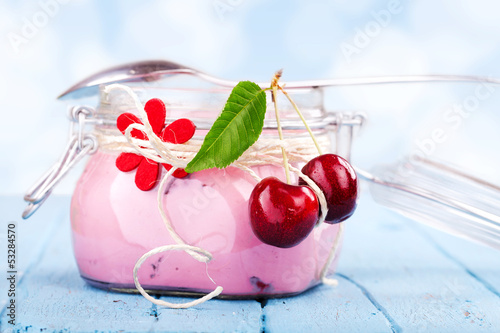 Photo: Kirschjoghurt vor blauen Hintergrund Kirschjoghurt vor blauen Hintergrund