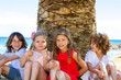 Children sitting next to palm tree.
